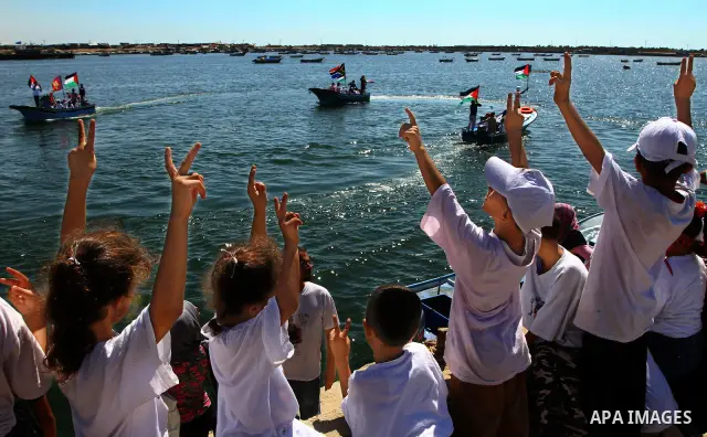 Palestinian children wave Palestinian flags along with the national flags of activists taking part in the Gaza-bound international Freedom Flotilla hoping to breach Israel's sea blockade on Gaza during a rally in Gaza Ci...
