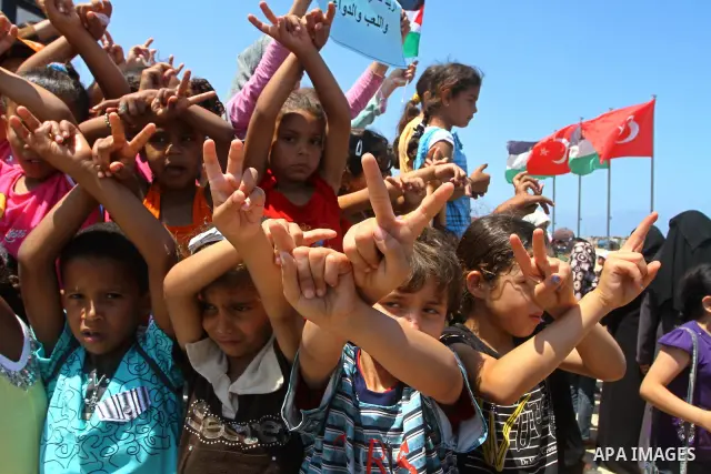 Palestinian children wave Palestinian flags along with the national flags of activists taking part in the Gaza-bound international Freedom Flotilla hoping to breach Israel's sea blockade on Gaza during a rally in Gaza Ci...