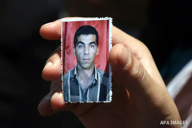 A Palestinian woman holds pictures of her relative held in Israeli jails during a protest calling for their release in the West Bank city of Ramallah on July 3, 2011. Israel currently holds about 5,600 Palestinian prison...