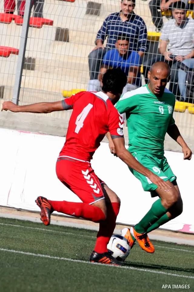 Palestinian player and Afghanistan player challenge for the ball during a soccer match between the Palestinian and Afghanistan national teams in the West bank city of Ramallah, Sunday July 3, 2011. The Palestinian nation...