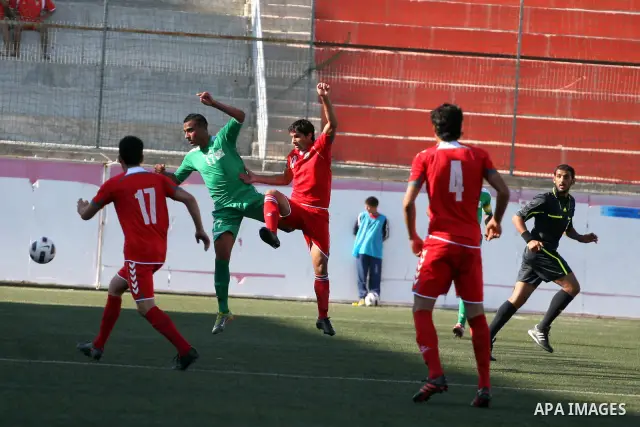Palestinian player and Afghanistan player challenge for the ball during a soccer match between the Palestinian and Afghanistan national teams in the West bank city of Ramallah, Sunday July 3, 2011. The Palestinian nation...