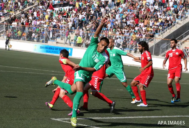 Palestinian player and Afghanistan player challenge for the ball during a soccer match between the Palestinian and Afghanistan national teams in the West bank city of Ramallah, Sunday July 3, 2011. The Palestinian nation...