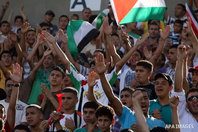 Palestinians watch their national soccer team play against Afghanistan national team in the West bank city of Ramallah, Sunday July 3, 2011. The Palestinian national soccer team drew 1-1 against Afghanistan on Sunday, a...