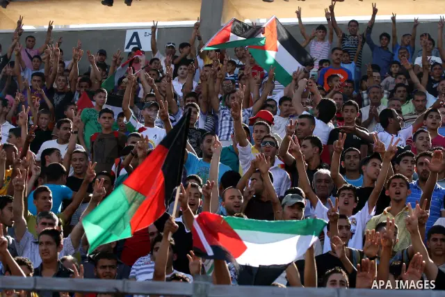 Palestinians watch their national soccer team play against Afghanistan national team in the West bank city of Ramallah, Sunday July 3, 2011. The Palestinian national soccer team drew 1-1 against Afghanistan on Sunday, a...