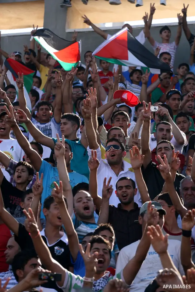 Palestinians watch their national soccer team play against Afghanistan national team in the West bank city of Ramallah, Sunday July 3, 2011. The Palestinian national soccer team drew 1-1 against Afghanistan on Sunday, a...