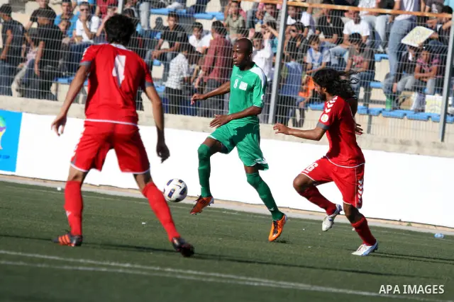Palestinian player and Afghanistan player challenge for the ball during a soccer match between the Palestinian and Afghanistan national teams in the West bank city of Ramallah, Sunday July 3, 2011. The Palestinian nation...