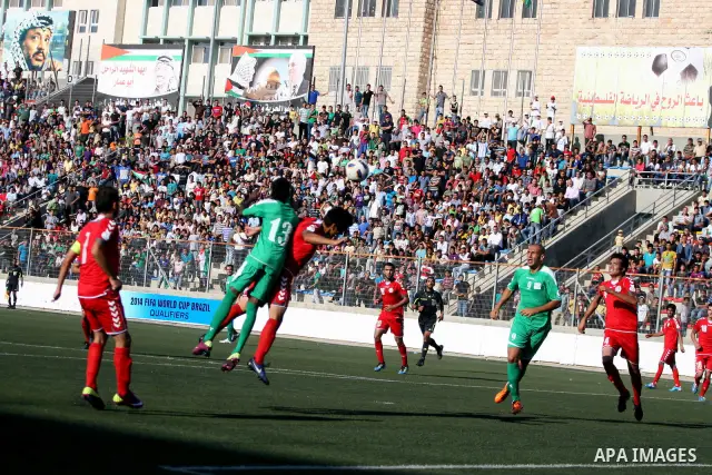 Palestinian player and Afghanistan player challenge for the ball during a soccer match between the Palestinian and Afghanistan national teams in the West bank city of Ramallah, Sunday July 3, 2011. The Palestinian nation...