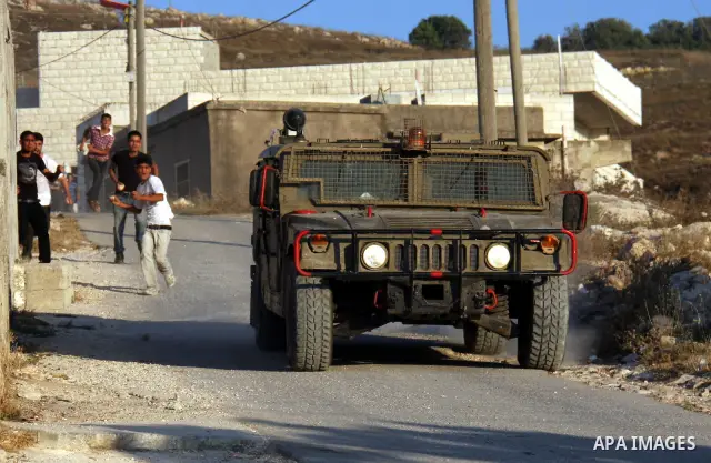 Palestinian youths hurl stones at Israeli troops during clashes over farming land between the Jewish settlement of Yitzhar and the nearby West Bank village of Asira, near Nablus, Sunday, July 3, 2011. Photo by Wagdi Esht...