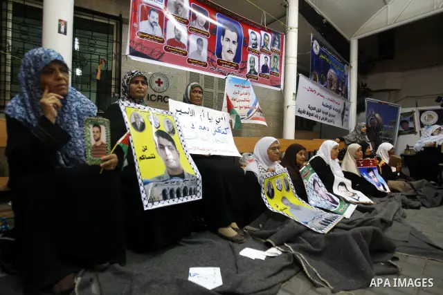 Relatives of Palestinian prisoners hold their pictures as they prepare to sleep at Gaza City's Red Cross offices on July 3,2011, during a protest calling for the release of Palestinian prisoners from Israeli jails. Photo...