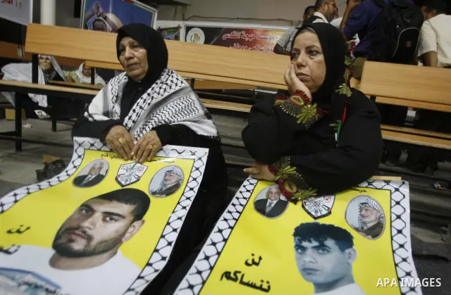Relatives of Palestinian prisoners hold their pictures as they prepare to sleep at Gaza City's Red Cross offices on July 3,2011, during a protest calling for the release of Palestinian prisoners from Israeli jails. Photo...