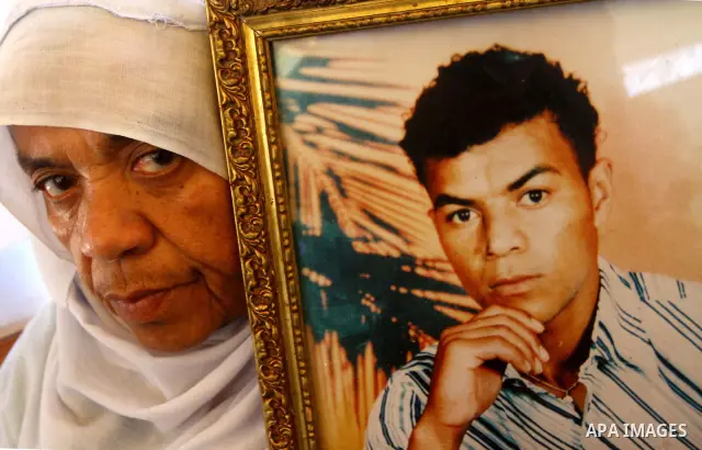 A Palestinian woman holds picture of her relative held in Israeli jails during a protest calling for their release in front of the Red Cross in Gaza city on July 4, 2011. Israel currently holds about 5,600 Palestinian pr...