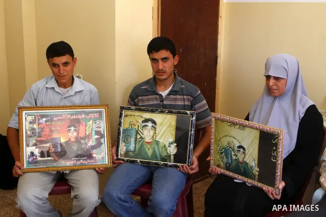 Relatives of the Palestinian Hosni Al-Hasi, who killed during a military attack in the former settlement of Doghit, hold his picture at their home in Gaza city on July 4,2011 .The Palestinian Authority and Israel agreed...