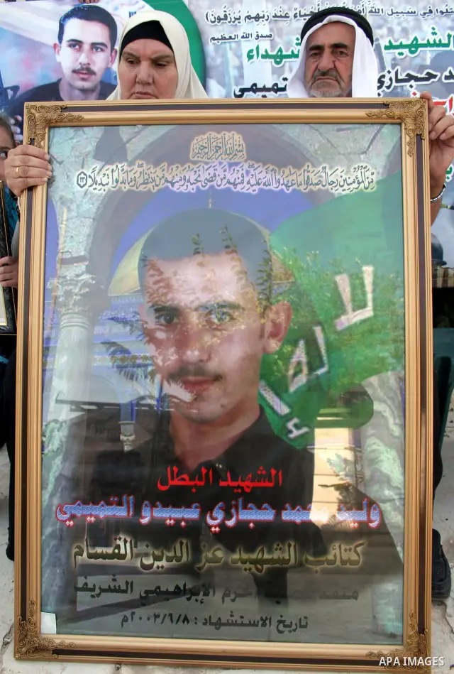 Palestinian relatives of Waleed Abedo hold his picture on July 4, 2011, in the West Bank town of Hebron, after Palestinian minister for civil affairs Hussein al-Sheikh announced that Israel is to release the bodies of 84...