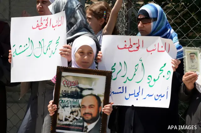 Palestinians take part in a protest in front of the Red Cross compound in the West Bank city of Ramallah on July 4, 2011 in support with Jerusalem's parliament members who have been living inside the ICRC compound in Jer...