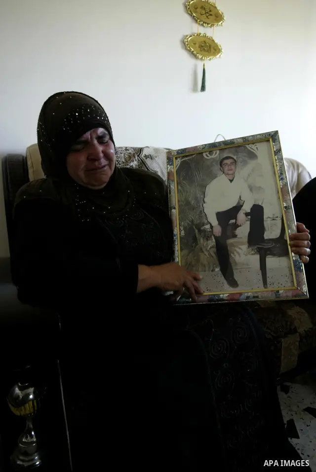 Palestinian relatives of Zeid Hanani hold his picture on July 4, 2011, in the West Bank town of Nablus, after Palestinian minister for civil affairs Hussein al-Sheikh announced that Israel is to release the bodies of 84...