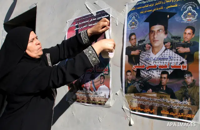 Palestinian relatives of Yousef Hanani hold his picture on July 4, 2011, in the West Bank town of Nablus, after Palestinian minister for civil affairs Hussein al-Sheikh announced that Israel is to release the bodies of 8...