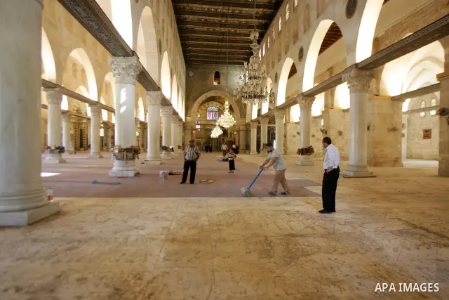 Palestinians fit rolls of new carpet inside the Al-Aqsa Mosque in Jerusalem's Old City on July 4, 2011. According to Sheikh Azzam Khatib, the head of the Islamic Waqf in Jerusalem, work have started to fit 5000 square me...