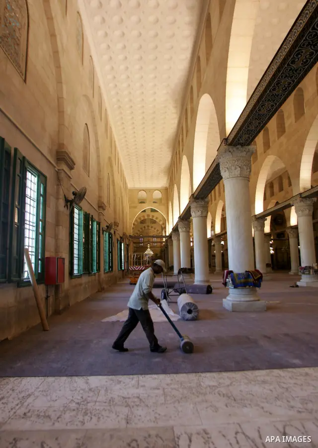 Palestinians fit rolls of new carpet inside the Al-Aqsa Mosque in Jerusalem's Old City on July 4, 2011. According to Sheikh Azzam Khatib, the head of the Islamic Waqf in Jerusalem, work have started to fit 5000 square me...