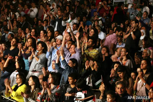 Palestinians attend a concert by Egyptian soft rock band Wast El Balad (lit: Downtown) during the opening ceremony of the 13th Palestine International Festival, in the West bank city of Ramallah on July 4, 2011. Where or...