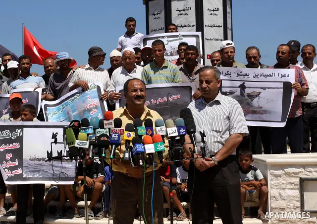Palestinian fishermen hold banners during a press conference in a rally in Gaza City in support of the international Freedom Flotilla hoping to breach Israel's sea blockade on Gaza as it remained banned by Greece from se...