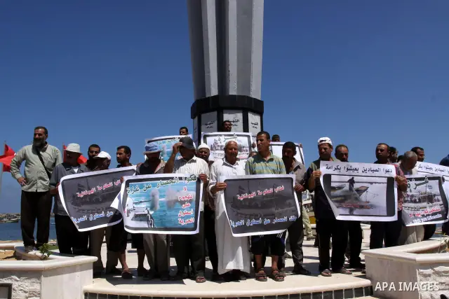 Palestinian fishermen hold banners during a rally in Gaza City in support of the international Freedom Flotilla hoping to breach Israel's sea blockade on Gaza as it remained banned by Greece from setting sail on July 5,...