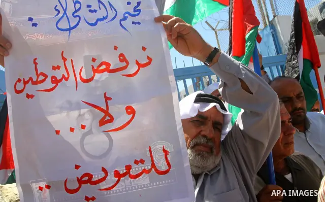 Palestinians hold their national flags during a protest in front of UNRWA headquarters in Gaza city on July 5, 2011. Dozens of Palestinians gather to protest against the UNRWA decision to change its name. Photo by Ashraf...