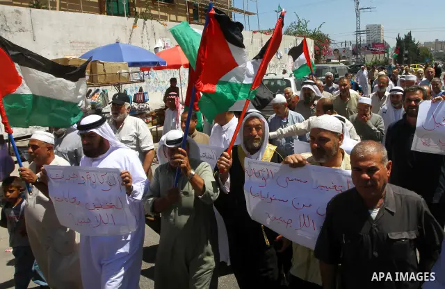 Palestinians hold their national flags during a protest in front of UNRWA headquarters in Gaza city on July 5, 2011. Dozens of Palestinians gather to protest against the UNRWA decision to change its name. Photo by Ashraf...