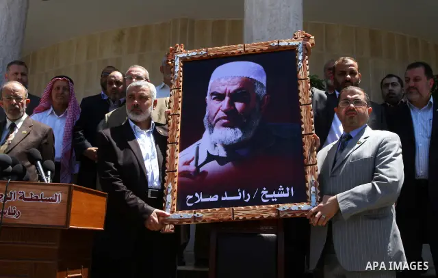 Palestinian Prime Minister in Gaza Strip, Ismail Haniya carries a picture of Sheikh Raed Salah in support with him in Gaza city o July 5, 2011. After the controversial Arab-Israeli Islamist leader was arrested in London...
