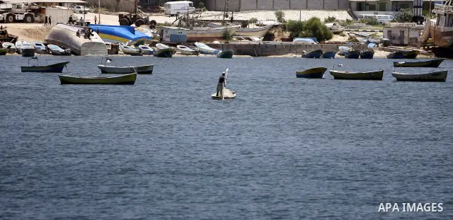 A Palestinian fisherman works on his boat in the port of Gaza City, Tuesday, July 5, 2011, as pro-Palestinian activists from an international flotilla banned from setting sail for Gaza by Greek authorities occupied the S...