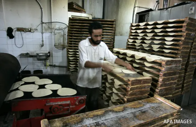 A Palestinian baker prepares bread at his bakery in Rafah, southern Gaza Strip on July 5,2011. Photo by Abed Rahim Khatib