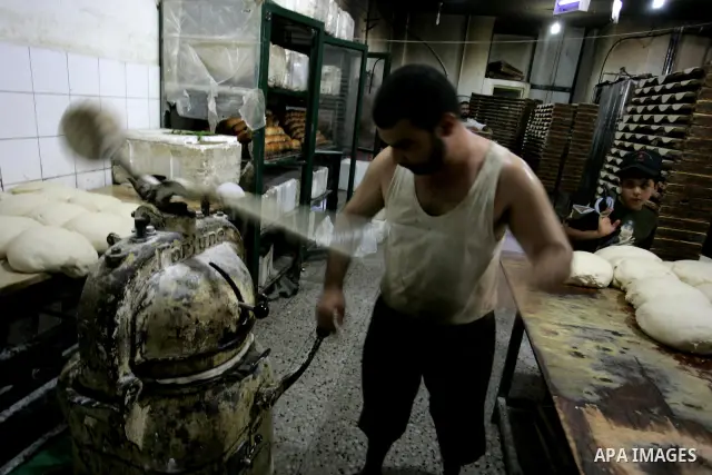 A Palestinian baker prepares bread at his bakery in Rafah, southern Gaza Strip on July 5,2011. Photo by Abed Rahim Khatib