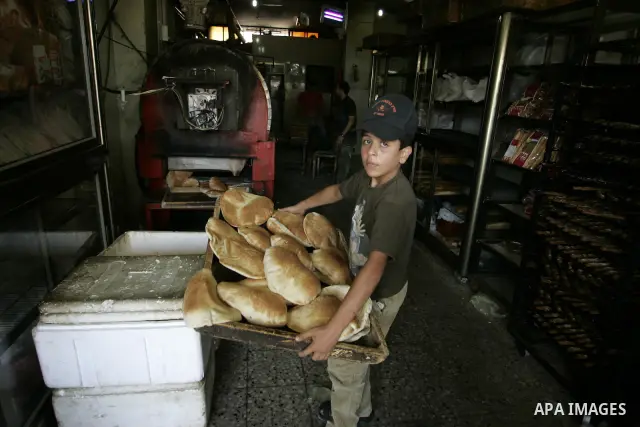 A Palestinian baker prepares bread at his bakery in Rafah, southern Gaza Strip on July 5,2011. Photo by Abed Rahim Khatib