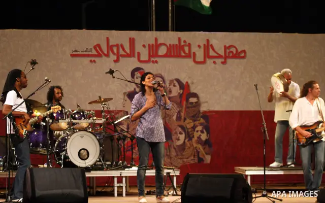 Souad Massi, an Algerian singer and songwriter living in France, performs during the Palestine International Festival 2011, in the West Bank city of Ramallah, Tuesday, July 5, 2011. The Arabic on the wall on the backgrou...