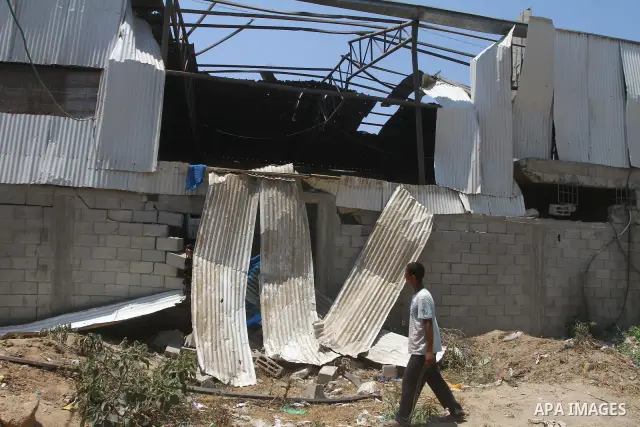 Palestinian youths inspect damage at a fodder storage following an Israeli air strike east of Gaza City, early Wednesday, July 6, 2011. Photo by Ashraf Amra