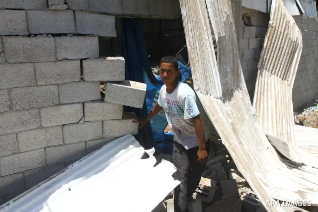 Palestinian youths inspect damage at a fodder storage following an Israeli air strike east of Gaza City, early Wednesday, July 6, 2011. Photo by Ashraf Amra
