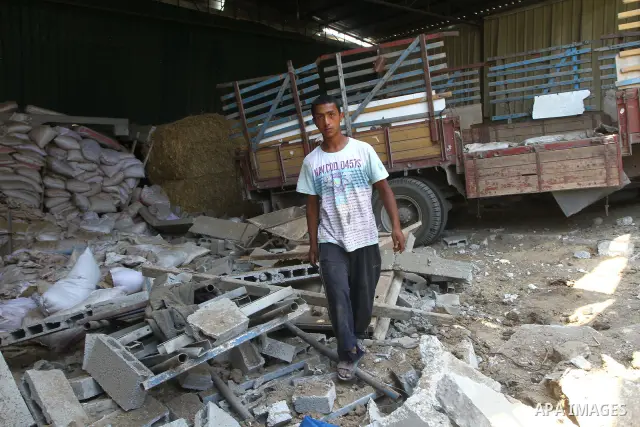 Palestinian youths inspect damage at a fodder storage following an Israeli air strike east of Gaza City, early Wednesday, July 6, 2011. Photo by Ashraf Amra