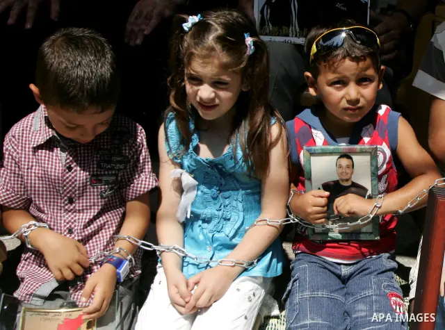 Pictures of Palestinian prisoners held in Israeli jails are held by their relatives during a protest in the Sheikh Jarrah neighbourhood in East Jerusalem July 6, 2011, calling for their release. Photo by Mahfouz Abu Turk