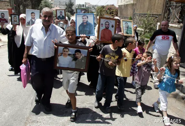 Pictures of Palestinian prisoners held in Israeli jails are held by their relatives during a protest in the Sheikh Jarrah neighbourhood in East Jerusalem July 6, 2011, calling for their release. Photo by Mahfouz Abu Turk
