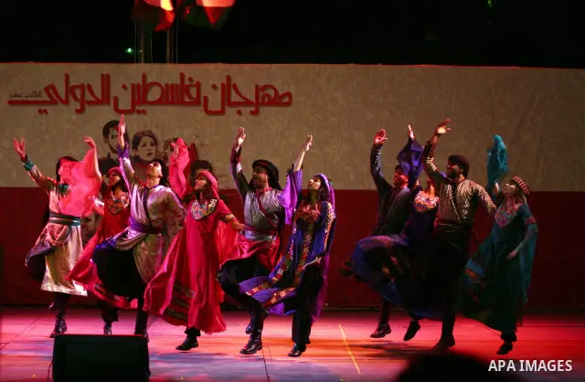 Dancers of the El-Funoun Palestinian Popular Dance Troupe perform on the third day of the 13th Palestine International Festival in the West Bank city of Ramallah on July 6, 2011. The festival, which features music and da...