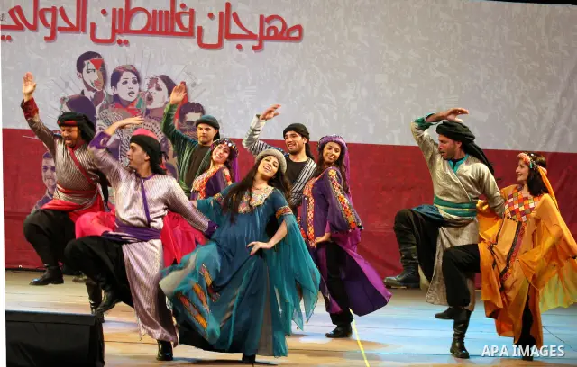 Dancers of the El-Funoun Palestinian Popular Dance Troupe perform on the third day of the 13th Palestine International Festival in the West Bank city of Ramallah on July 6, 2011. The festival, which features music and da...