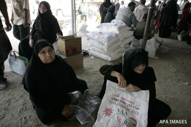 Palestinians receive humanitarian aid at the United Nations aid distribution centre in the refugee camp of Rafah in the southern Gaza Strip on July 7, 2011. United Nations Relief and Works Agency (UNRWA) decide to change...
