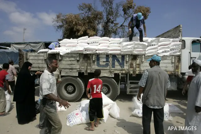 Palestinians receive humanitarian aid at the United Nations aid distribution centre in the refugee camp of Rafah in the southern Gaza Strip on July 7, 2011. United Nations Relief and Works Agency (UNRWA) decide to change...