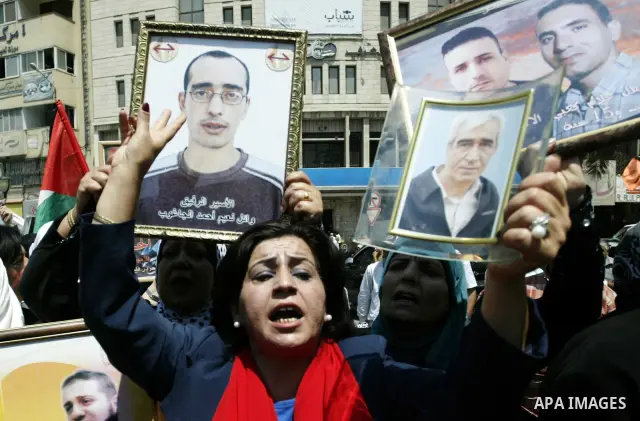 Palestinian women hold pictures of their relatives, held in Israeli jails, during a protest calling for their release in the West Bank city of Nablus, Thursday, July 7, 2011. Israel currently holds about 5,600 Palestinia...