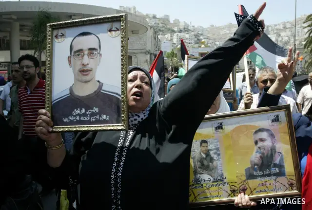 Palestinian women hold pictures of their relatives, held in Israeli jails, during a protest calling for their release in the West Bank city of Nablus, Thursday, July 7, 2011. Israel currently holds about 5,600 Palestinia...