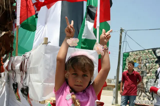 Palestinian protesters from the West Bank village of Nabi Salih, north of Ramallah stand next to a symbolic flotilla boat on 08 July 2011 during the weekly Friday protest against the continuations of the construction in...