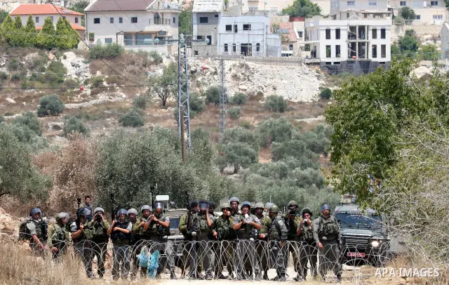 Israeli soldiers take positions as Palestinians protest in the village of Kufr Qaddum near the Israeli settlement of Kdumim, in the northern West Bank Friday, July 8, 2011. The protest concerned Palestinian access to lan...