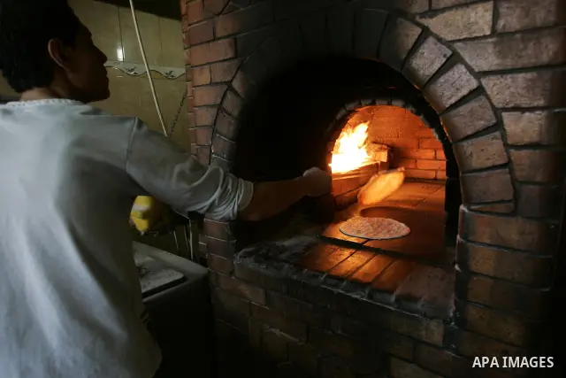 A Palestinian man bakes bread at a restaurant in Rafah, southern Gaza Strip on July 9,2011. While the Palestinian President Mahmoud Abbas said that the financial crisis with the authority's real and difficult and we need...
