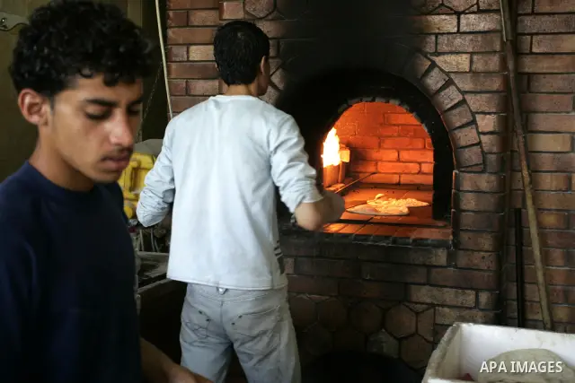 A Palestinian man bakes bread at a restaurant in Rafah, southern Gaza Strip on July 9,2011. While the Palestinian President Mahmoud Abbas said that the financial crisis with the authority's real and difficult and we need...