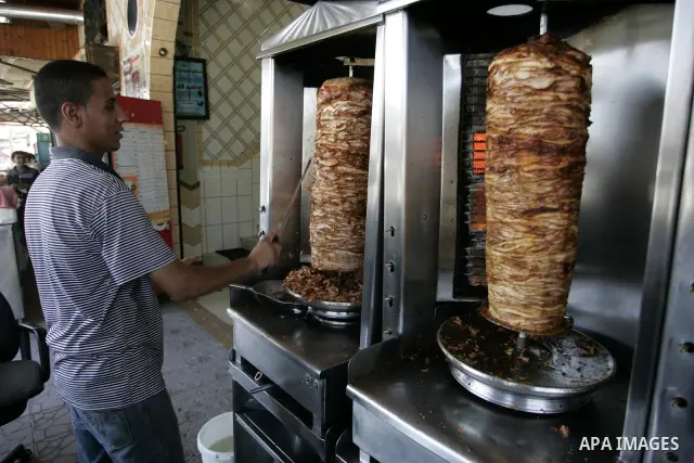 A Palestinian man prepares grilled meat at a restaurant in Rafah, southern Gaza Strip on July 9, 2011. While the Palestinian President Mahmoud Abbas said that the financial crisis with the authority's real and difficult...