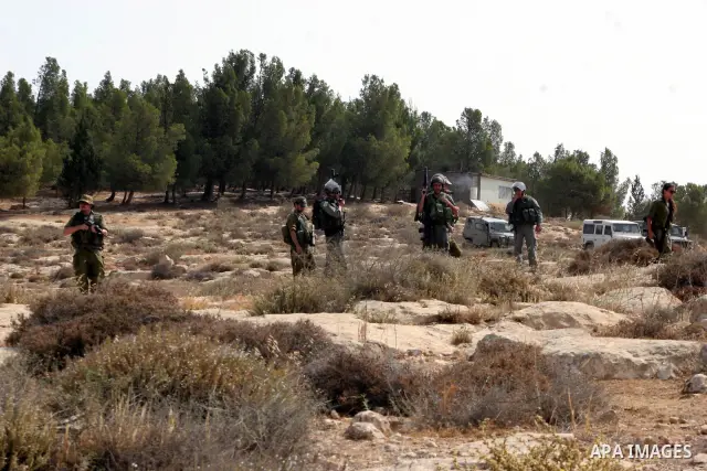 Palestinian, foreign and Israeli protesters run for cover as Israeli troops fire tear gas to disperse the protesters during a demonstration against the demolishing of farm land to be used in the construction of Jewish se...